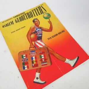 Puede incluir: Un programa amarillo y rojo para la 24ª temporada de los Harlem Globetrotters, 1950-1951. La portada presenta una ilustración de dibujos animados de un jugador de baloncesto driblando un balón y sosteniendo una maleta con banderas que representan los países que el equipo ha recorrido.