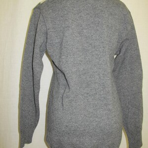May include: A gray long-sleeved sweater with a V-neck.