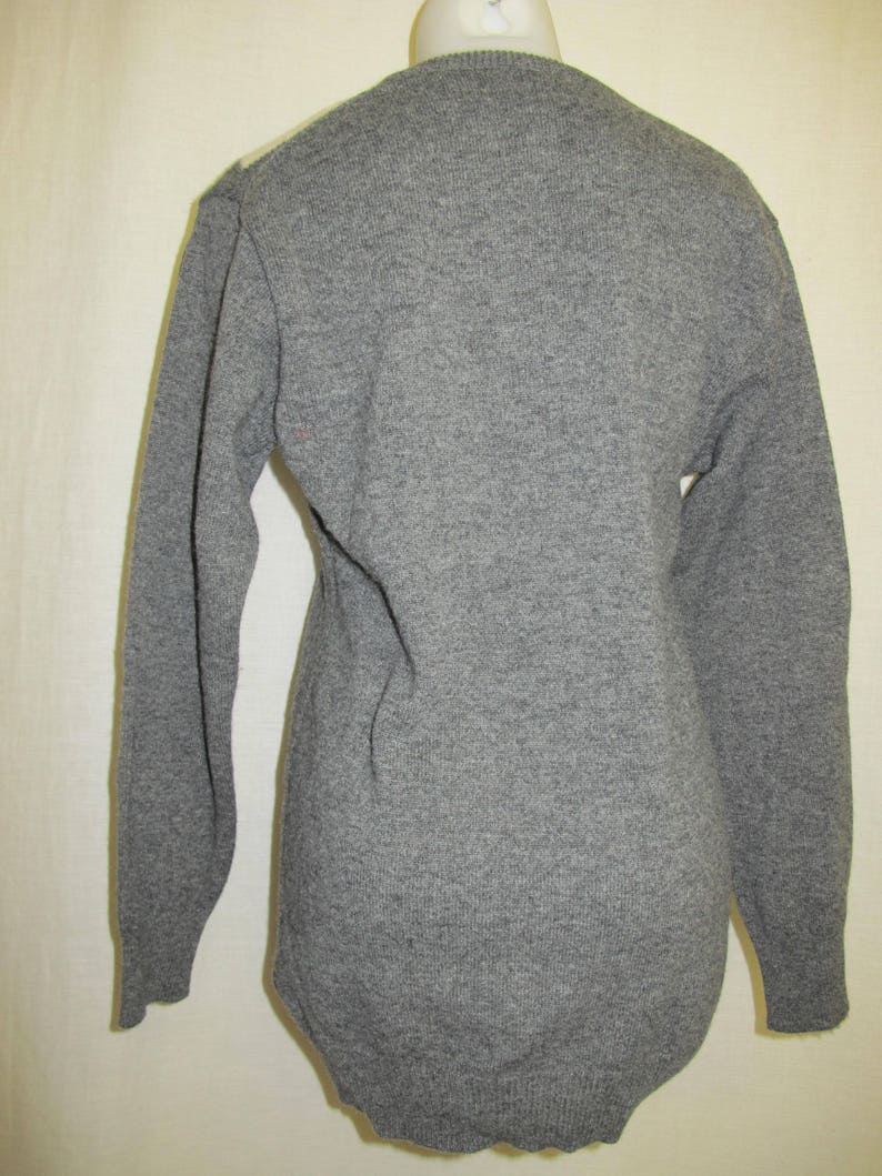 May include: A gray long-sleeved sweater with a V-neck.