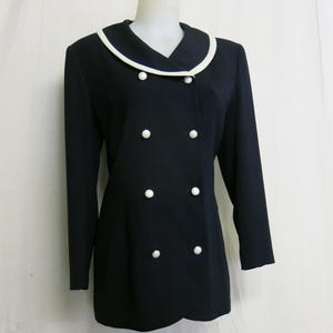 May include: A black blazer with a white collar and white buttons. The blazer has a double-breasted closure.
