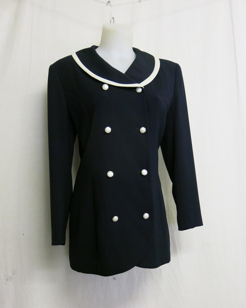 May include: A black blazer with a white collar and white buttons. The blazer has a double-breasted closure.