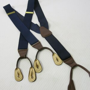 Puede incluir: Tirantes azul marino con detalles de cuero marrón y ajustadores metálicos dorados. Los tirantes tienen un diseño clásico con enganches de cuero. Un accesorio elegante para pantalones.