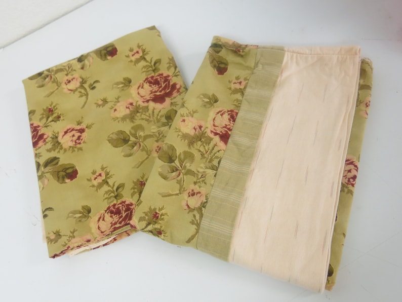 May include: Two fabric panels with a floral pattern. The panels are green with a red and white floral design. One panel has a solid beige backing.
