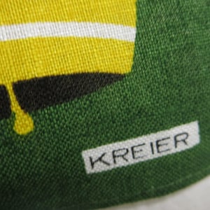 Op de afbeelding: Close-up van een groene stof met een wit label waarop "KREIER" staat.