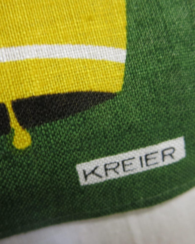Op de afbeelding: Close-up van een groene stof met een wit label waarop "KREIER" staat.