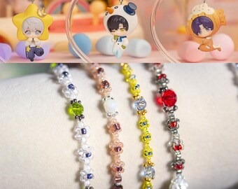 May include: Five beaded bracelets with different colored beads and charms. The bracelets are made with white, pink, yellow, and black beads. The charms include a green bead, a white bead, a clear bead, and a red bead.