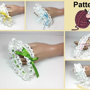 Può includere: Un set di quattro giarrettiere all'uncinetto con nastri di diversi colori. Le giarrettiere sono bianche con delicati dettagli in pizzo. I nastri sono gialli, blu, rosa e verdi.