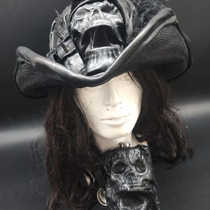 Sombrero pirata de cuero negro con calavera moldeada en 3D y petaca a juego.