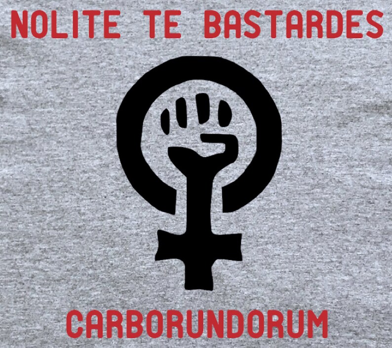 May include: A gray t-shirt with a black feminist symbol and the text "NOLITE TE BASTARDES CARBORUNDORUM" in red.