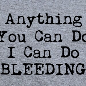 May include: A gray t-shirt with the text "Anything You Can Do I Can Do Bleeding" printed in black.