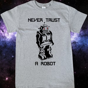 May include: A gray t-shirt with a black robot graphic and the text "NEVER TRUST A ROBOT".