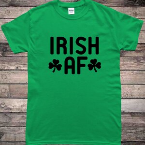 May include: Green t-shirt with black text that reads "IRISH AF" with shamrock symbols on either side of the "AF".