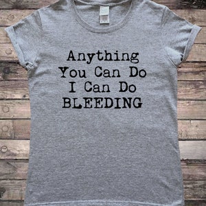 May include: Gray t-shirt with black text that reads "Anything You Can Do I Can Do Bleeding".