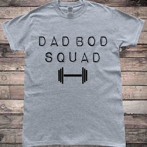 May include: Gray t-shirt with the text "DAD BOD SQUAD" and a black dumbbell graphic.