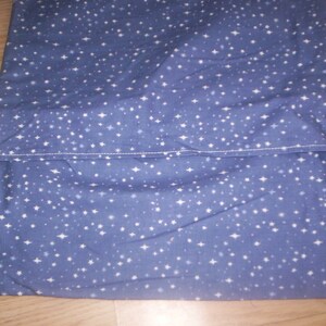 May include: A blue fabric with a white star pattern. The fabric is folded in half and sewn together.