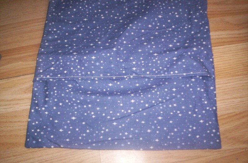 May include: A blue fabric with a white star pattern. The fabric is folded in half and sewn together.