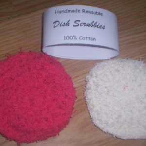 May include: Two handmade, reusable dish scrubbies made of 100% cotton. One is red and the other is white.