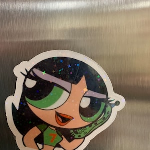 May include: A green, black, and white cartoon sticker of a girl with green eyes and black hair. She is wearing a green shirt with a number 7 on it. She is holding a green phone to her ear. The sticker has a glittery finish.