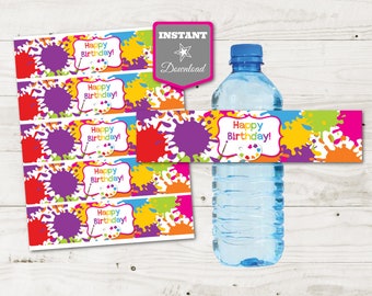 Puede incluir: Botella de agua con una colorida etiqueta de Feliz Cumpleaños. La etiqueta presenta salpicaduras de pintura en morado, rojo, amarillo, naranja y verde. Las palabras "¡Feliz Cumpleaños!" están en un marco blanco.