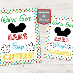 May include: Two printable signs with a white background and colorful polka dots. The signs feature a black silhouette of Mickey Mouse's head with ears and a black hat. The text on the signs reads "We've Got Ears Say Cheers!"