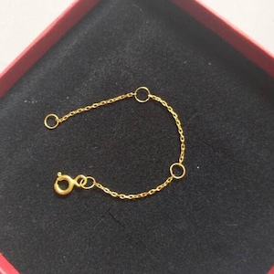 May include: A gold chain bracelet with three small circular links. The bracelet has a lobster clasp.