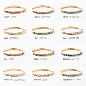 May include: Twelve gold rings with different colored gemstones, each representing a different month of the year. January: Garnet, February: Amethyst, March: Aquamarine, April: Diamond, May: Emerald, June: Alexandrite, July: Ruby, August: Peridot, September: Sapphire, October: Pink Tourmaline, November: Citrine, December: Blue Topaz.