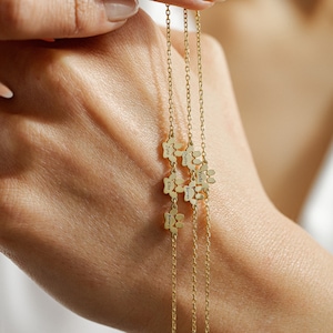 May include: Three gold chains with paw print charms, each charm engraved with a different name: Juno, Chester, Yoda, Barnes, Kiko, and Barry.