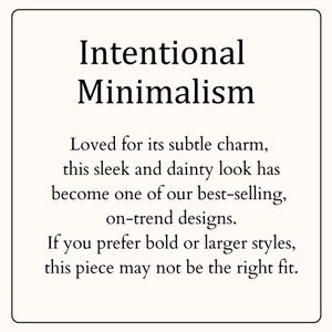 May include: A square graphic with a cream background and a thin black border. The text reads: Intentional Minimalism. Loved for its subtle charm, this sleek and dainty look has become one of our best-selling, on-trend designs. If you prefer bold or larger styles, this piece may not be the right fit.