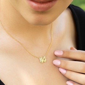 May include: A gold chain necklace with a delicate monogram pendant featuring the letters "MFS".