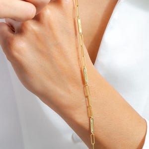 May include: Gold chain necklace with four rectangular name tags. The name tags are engraved with the names "Jason", "Sarah", "Josh", and "Noah".