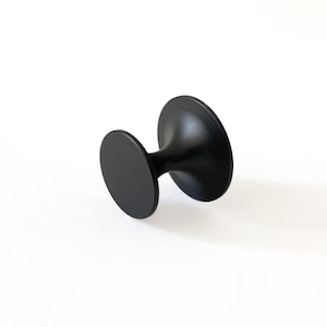 May include: Black cabinet knob with a round base and a round top.