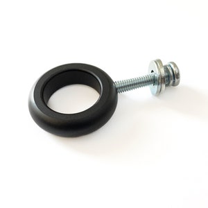 May include: Black metal ring with a screw and washer. The ring is designed to be attached to a surface.