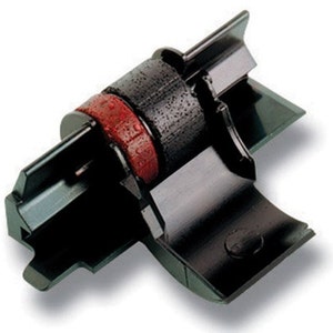 Könnte beinhalten: Schwarze Tintenbandkassette für eine Schreibmaschine. Das Band ist rot und schwarz und ist auf einer schwarzen Kunststoffspule befestigt.