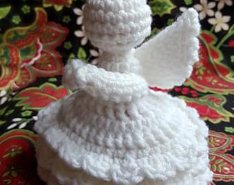May include: White crocheted angel ornament with a gold halo. The angel is wearing a white dress with a ruffled skirt and has wings.