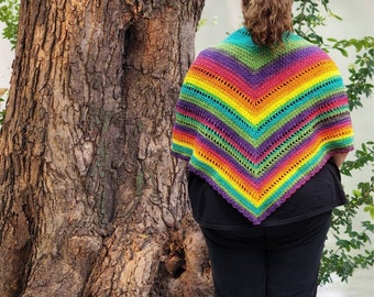 May include: A rainbow crochet shawl with a colorful striped pattern. The shawl is made with a variety of colors, including red, orange, yellow, green, blue, and purple.