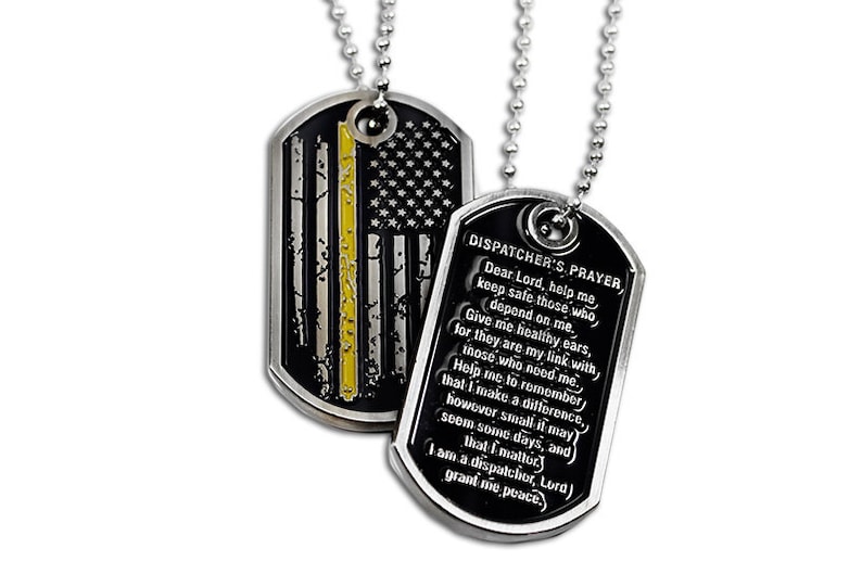 May include: Two silver dog tags on a silver chain. One tag features a black and white American flag with a yellow stripe, the other tag has a black background with the text "DISPATCHER'S PRAYER" and a prayer for dispatchers.