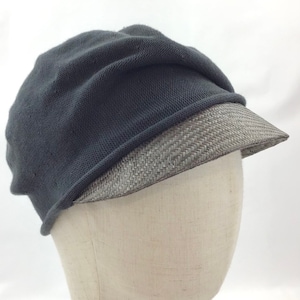 May include: A dark gray knit cap with a woven brim. The cap is displayed on a mannequin head against a white background. The hat has a rounded crown and a short, slightly curved brim.