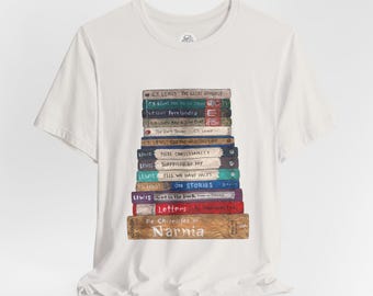 May include: White t-shirt featuring a stack of books with titles by C.S. Lewis, including "The Chronicles of Narnia" and "Mere Christianity." The books are in various colors, with the titles clearly visible. The shirt is made of a soft material.