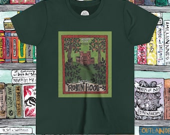 May include: Dark green t-shirt featuring a framed illustration of a castle scene with trees and the text "The Adventures of Robin Hood." The design is in shades of green, brown, and red. The shirt is surrounded by a bookshelf.