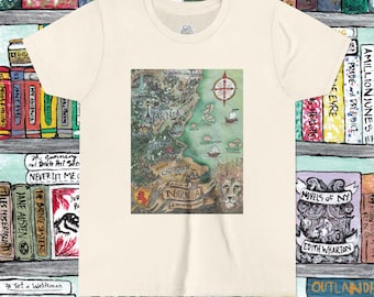 May include: Cream-colored t-shirt featuring a detailed map of Narnia with a compass rose, ships, and the lion Aslan. The map includes the text "NARNIA" and "CALORMEN". The shirt is surrounded by a bookshelf filled with classic literature.