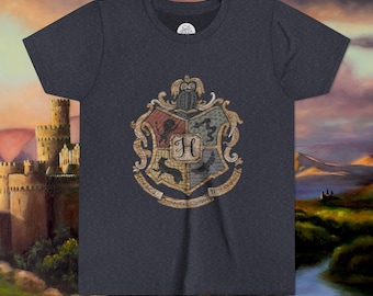 May include: Dark gray t-shirt featuring a detailed crest with the letter "H" at the center. The crest is in shades of red, gold, green, and blue. The shirt is a crew neck style.