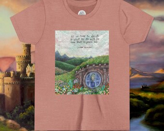 May include: A dusty rose t-shirt featuring a colorful illustration of a hobbit hole with a blue door, surrounded by flowers and rolling green hills. The shirt has the quote "All we have to decide is what to do with the time that is given us."