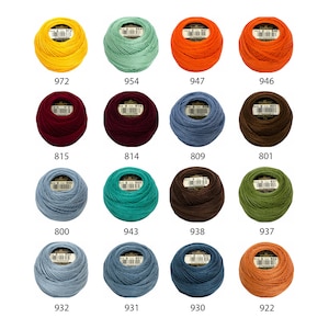 May include: A collection of 12 balls of embroidery floss in various colors, including yellow, green, orange, red, brown, teal, dark brown, olive green, blue, and orange. Each ball has a label with a number.