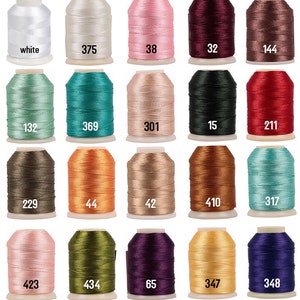 May include: A collection of 20 spools of thread in various colors, including white, pink, red, green, brown, orange, and purple. Each spool is labeled with a number.
