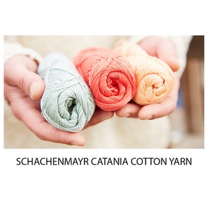 May include: Three balls of cotton yarn in shades of green, coral, and peach. The yarn is labelled "Schachenmayr Catania Cotton Yarn".