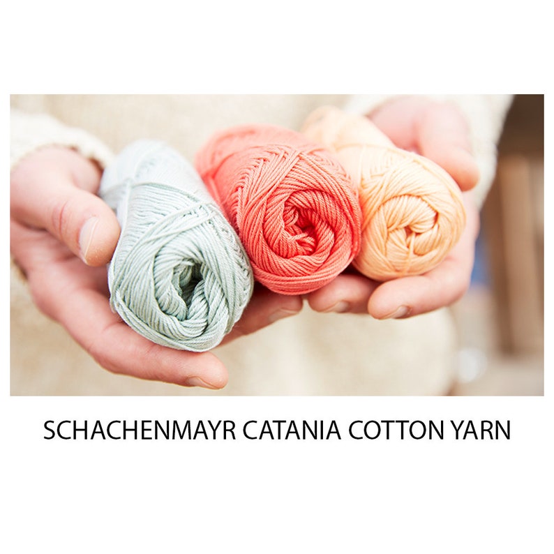 May include: Three balls of cotton yarn in shades of green, coral, and peach. The yarn is labelled "Schachenmayr Catania Cotton Yarn".