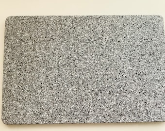 May include: A gray rectangular cutting board with a speckled surface.