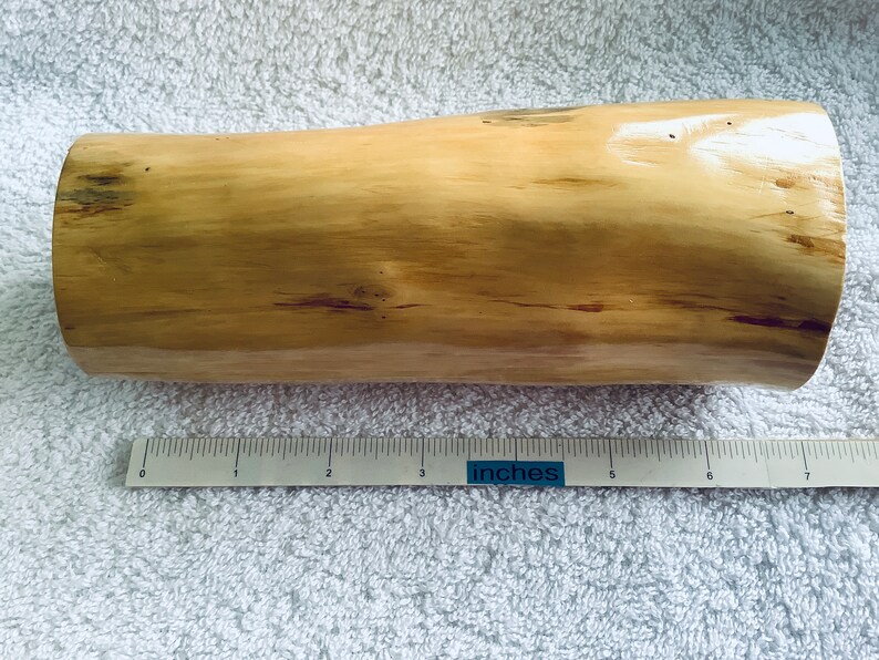 May include: A light brown wooden log, approximately 18 cm long, with a smooth, polished surface. The log has a natural, rustic appearance with subtle variations in colour and texture.