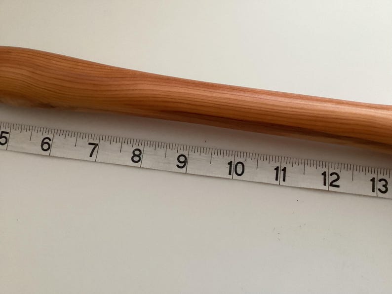May include: A close-up of a wooden dowel rod measuring 13 inches in length. The rod is light brown in colour and has a smooth, polished finish.