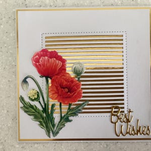 May include: A white greeting card with a gold border and accents. The card features a watercolour illustration of red poppies with green leaves. Gold horizontal stripes and the words "Best Wishes" are also included.